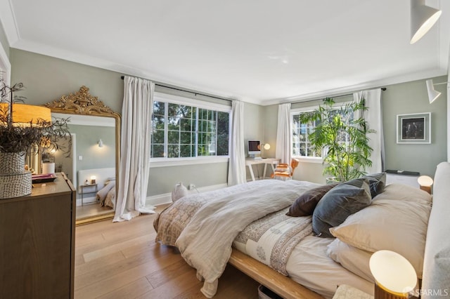 bedroom featuring light wood-style flooring and ornamental molding