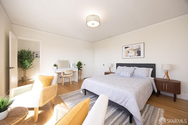 bedroom featuring light wood finished floors and ornamental molding