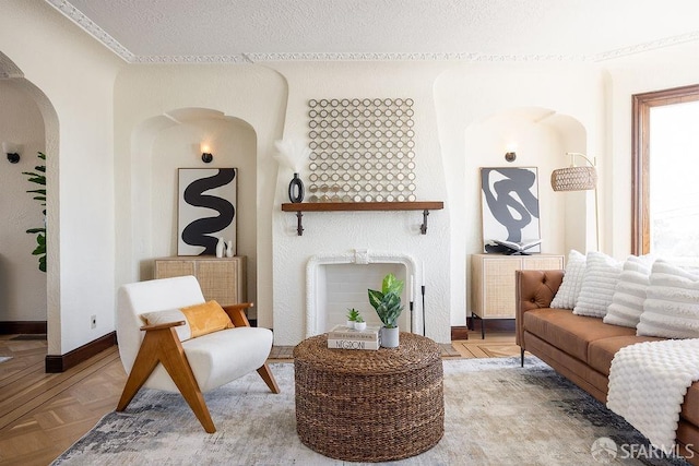 interior space with baseboards, arched walkways, and a textured ceiling