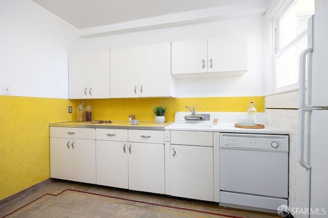 kitchen with a wainscoted wall, white cabinetry, white appliances, tile walls, and light countertops