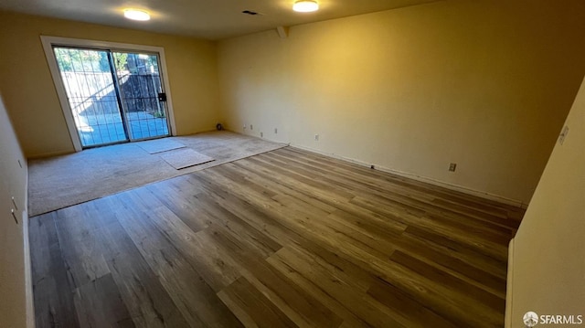 spare room with wood finished floors and visible vents