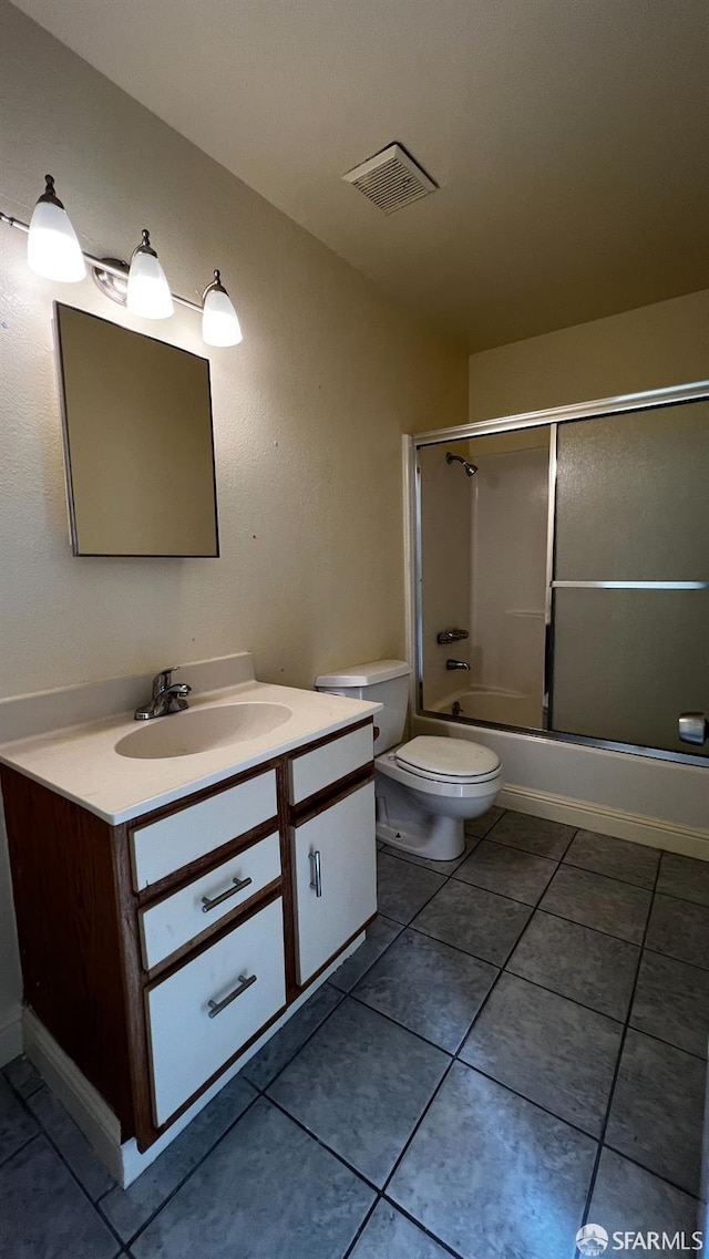 full bathroom featuring visible vents, toilet, shower / bath combination with glass door, tile patterned flooring, and vanity