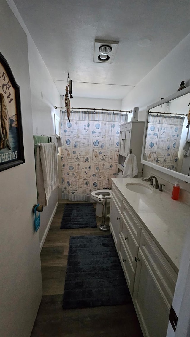 full bathroom with toilet, visible vents, wood finished floors, curtained shower, and vanity