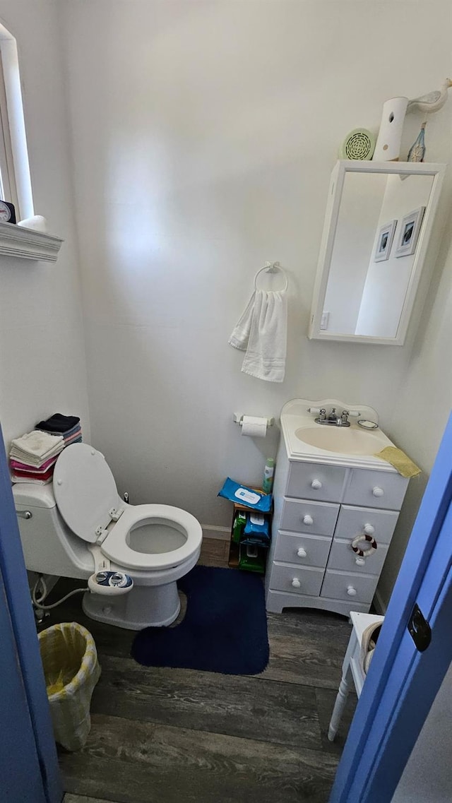 bathroom with wood finished floors, vanity, and toilet