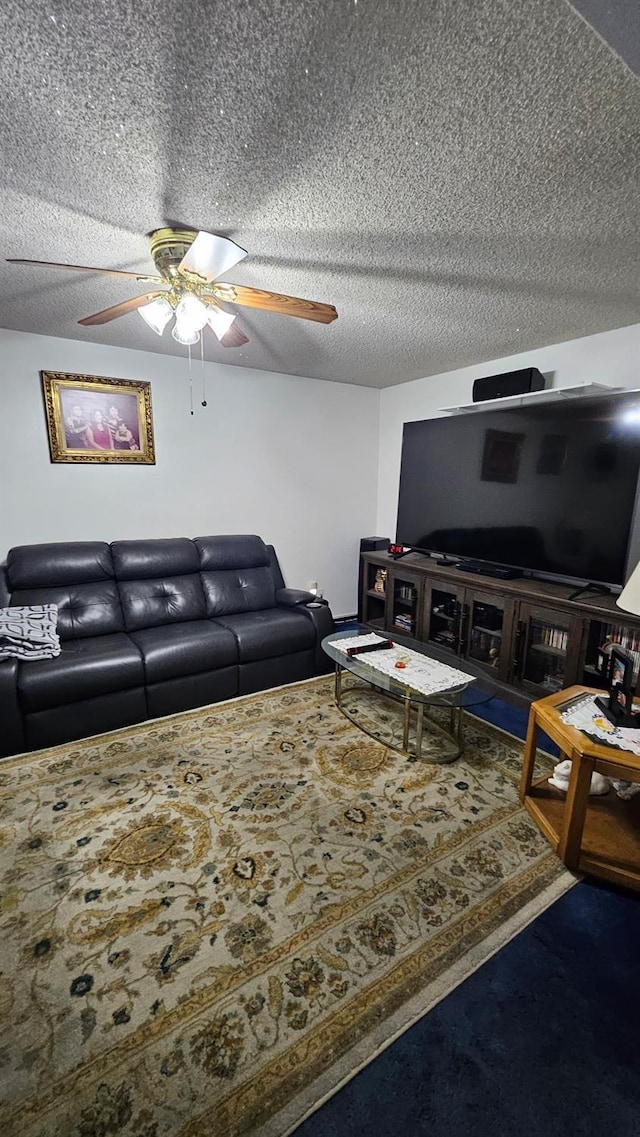 living area with a textured ceiling and a ceiling fan