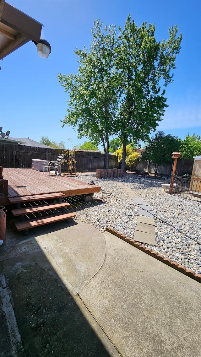 view of yard with a fenced backyard and a deck