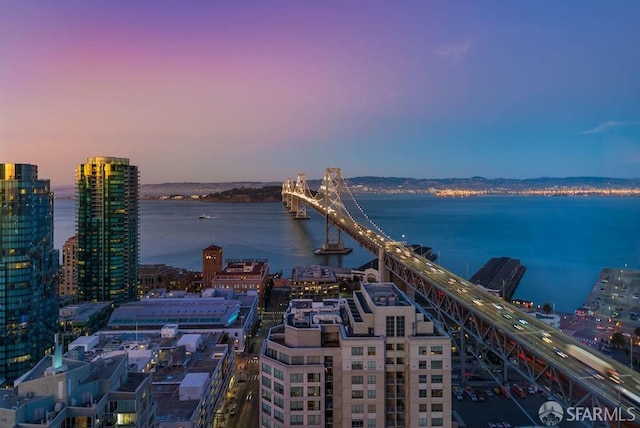 aerial view at dusk featuring a water view