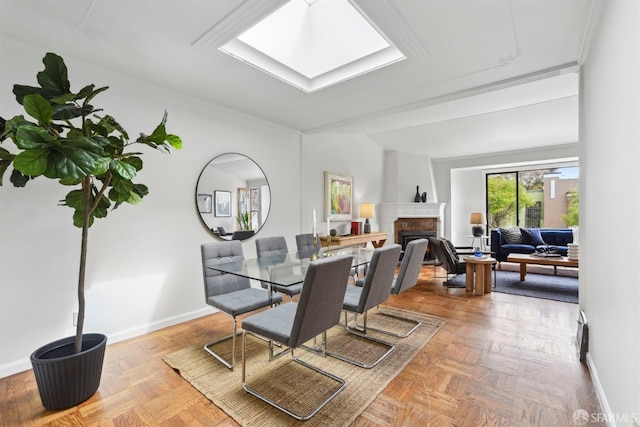 dining room with baseboards and a fireplace