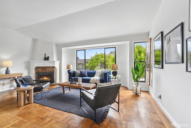 living area featuring baseboards and a warm lit fireplace