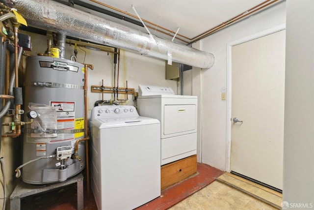 laundry area featuring laundry area, washing machine and clothes dryer, and secured water heater