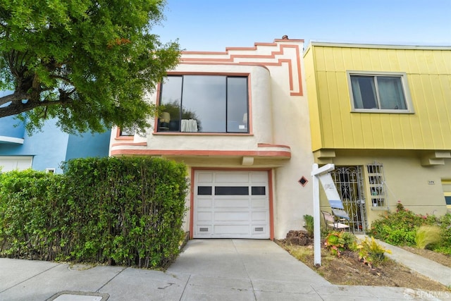 multi unit property featuring stucco siding, driveway, and a garage