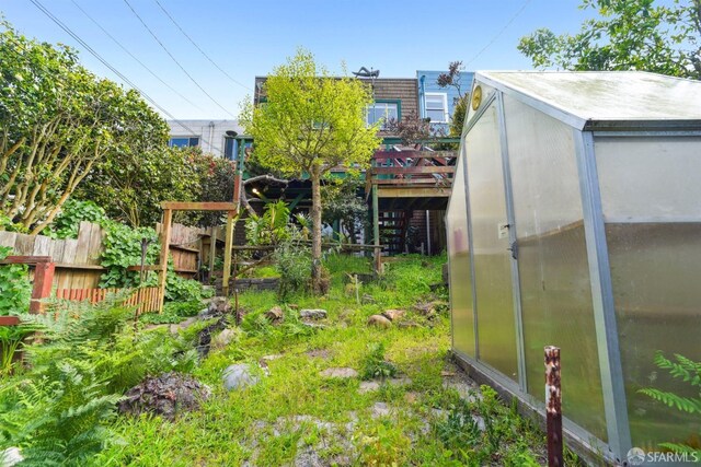 view of yard with fence, an outbuilding, and an exterior structure