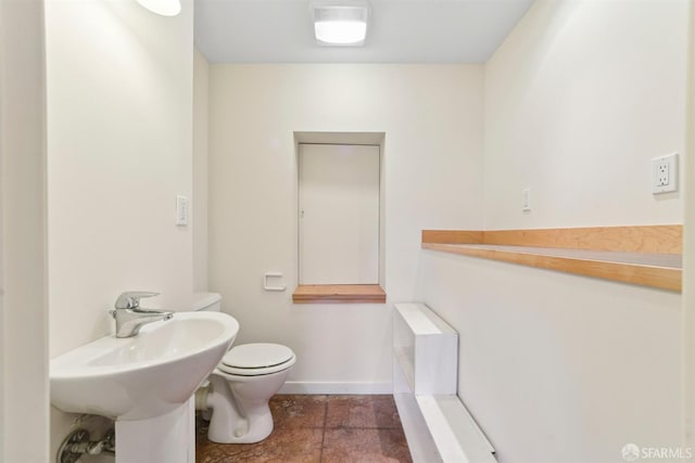 bathroom with toilet and stone finish flooring