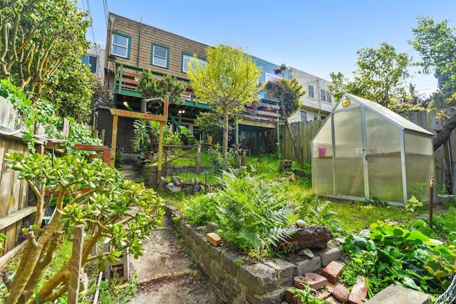 view of yard featuring an outbuilding, an exterior structure, fence private yard, and a vegetable garden