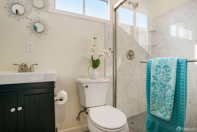 bathroom featuring vanity, toilet, and a shower with door