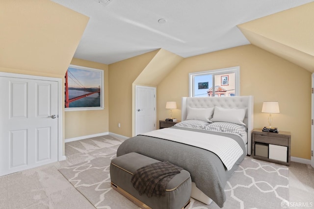 bedroom with light carpet and lofted ceiling