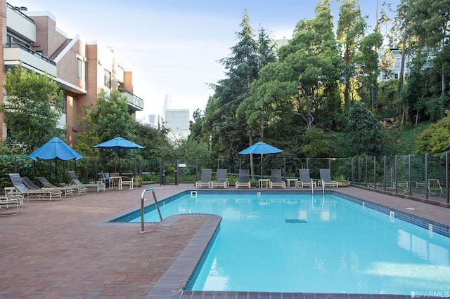 pool with a patio and fence