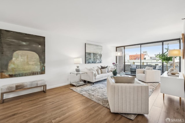 living room with baseboards, wood finished floors, and floor to ceiling windows