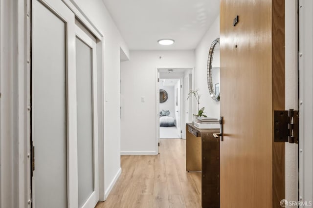 hallway featuring light wood-style floors and baseboards