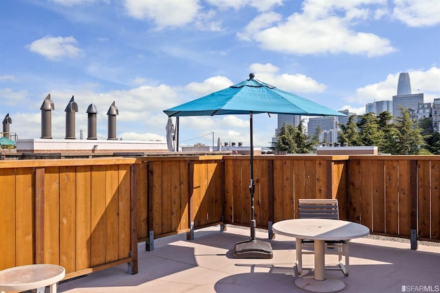 view of patio featuring a city view and fence