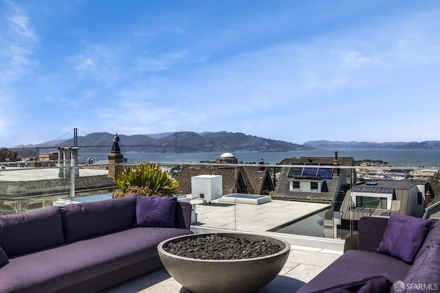 view of patio / terrace with a balcony, outdoor lounge area, and a water and mountain view