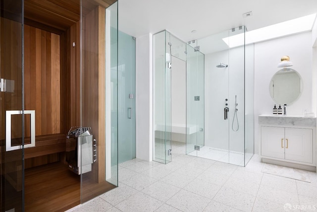 bathroom featuring vanity, an enclosed shower, and a skylight