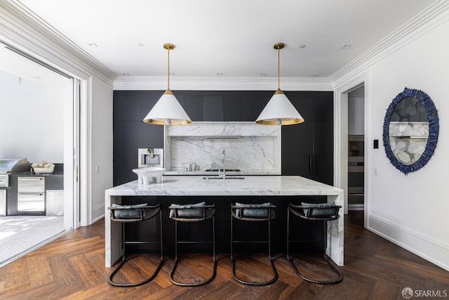 kitchen with dark parquet floors, light stone counters, a kitchen bar, and decorative light fixtures