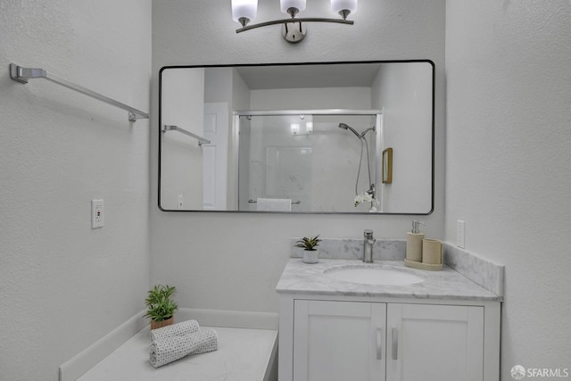 bathroom with a shower with door and vanity