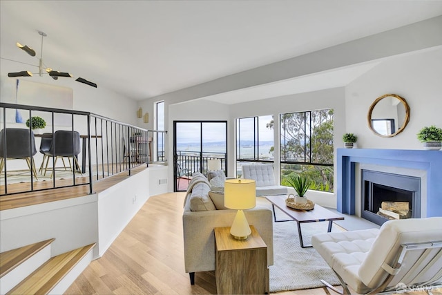 living room with lofted ceiling, light hardwood / wood-style floors, and ceiling fan