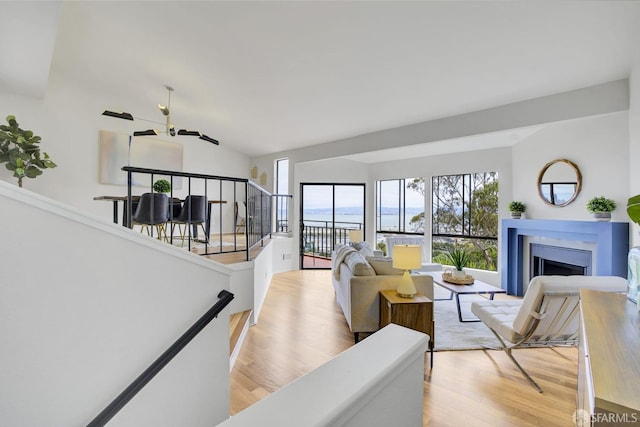 living room featuring lofted ceiling, a water view, ceiling fan, and light hardwood / wood-style flooring