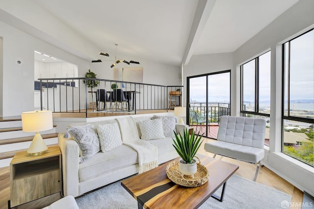 living room featuring lofted ceiling, light hardwood / wood-style floors, and a healthy amount of sunlight