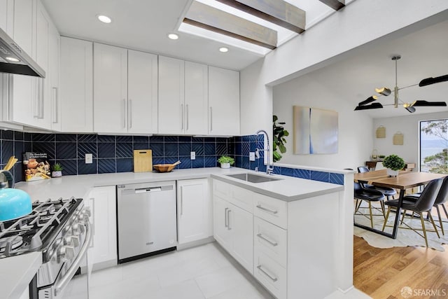 kitchen with ventilation hood, stainless steel appliances, sink, and white cabinetry