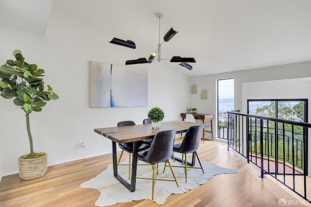 dining space featuring light hardwood / wood-style flooring and vaulted ceiling