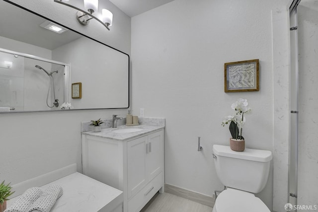 bathroom with vanity, a shower with shower door, and toilet