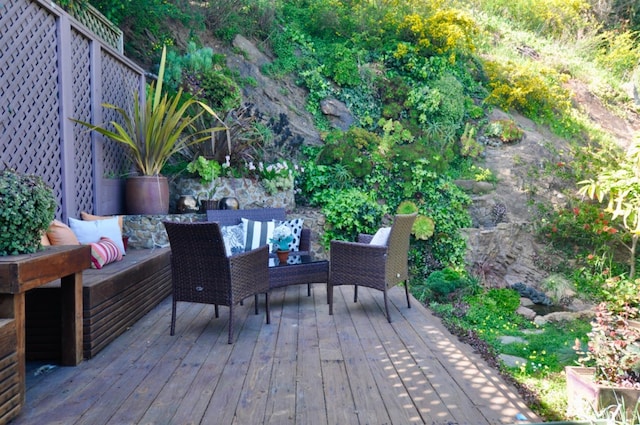 wooden terrace with an outdoor living space