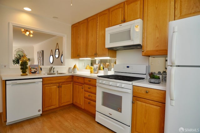 kitchen with white appliances, light wood-style flooring, a sink, light countertops, and brown cabinets