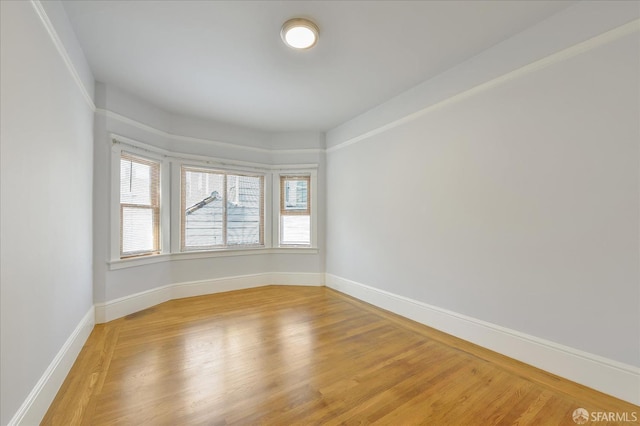 unfurnished room featuring light wood-type flooring and baseboards