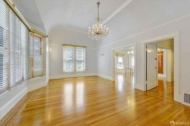 empty room with visible vents, baseboards, an inviting chandelier, ornamental molding, and light wood finished floors