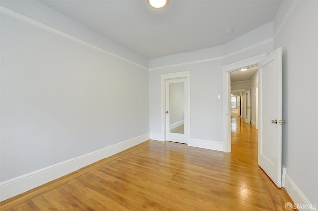 spare room featuring light wood finished floors and baseboards