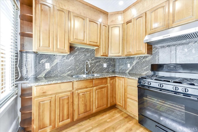 kitchen with open shelves, a sink, under cabinet range hood, black range with gas stovetop, and light stone counters
