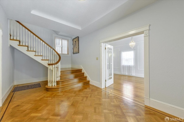 interior space with stairs, a notable chandelier, baseboards, and a healthy amount of sunlight