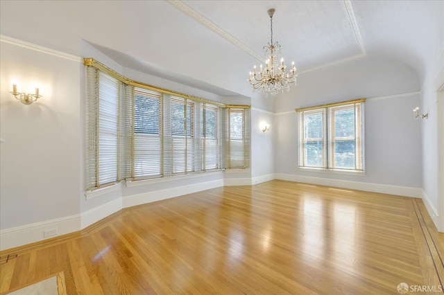 empty room featuring light wood-style floors, an inviting chandelier, baseboards, and lofted ceiling