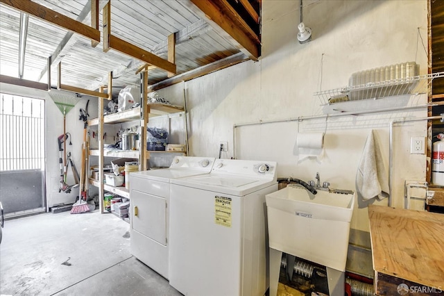 washroom featuring laundry area, a sink, and washer and clothes dryer