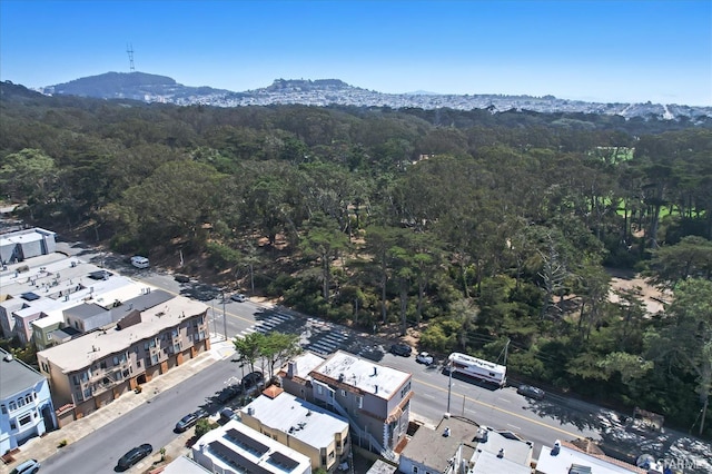 birds eye view of property featuring a wooded view and a mountain view