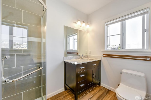 full bathroom featuring toilet, a tile shower, wood finish floors, and plenty of natural light