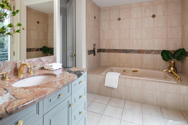 bathroom featuring tile walls, tile patterned flooring, tiled bath, and vanity