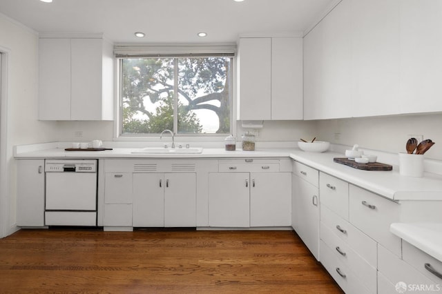 kitchen with dark hardwood / wood-style flooring, dishwasher, white cabinetry, and sink