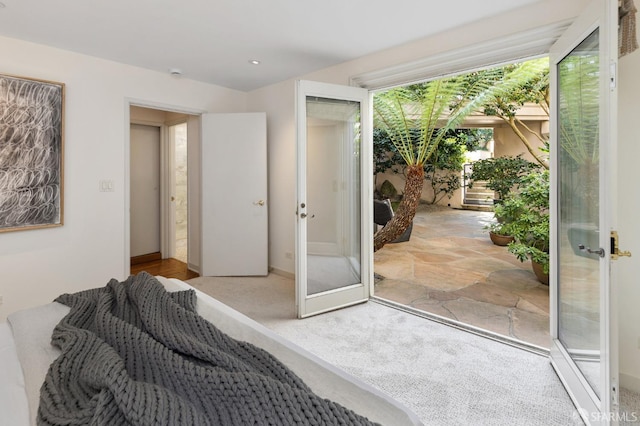 bedroom with light colored carpet, french doors, and a closet