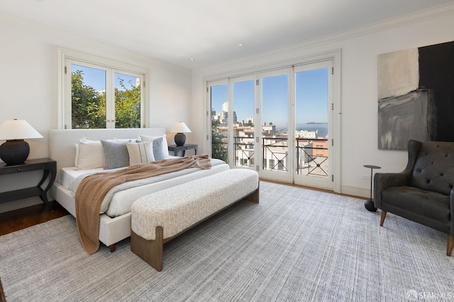 bedroom with wood-type flooring, ornamental molding, french doors, and access to exterior