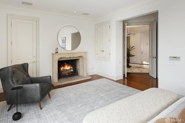 bedroom with crown molding, dark hardwood / wood-style floors, and a high end fireplace